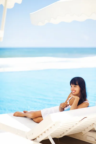 Woman relaxing in resort on a sunbed — Stock Photo, Image