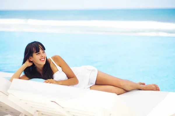 Mulher relaxante no resort em uma espreguiçadeira — Fotografia de Stock