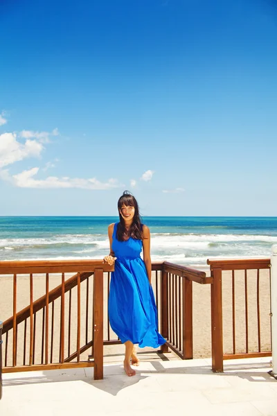 Γυναίκα σε μπλε φόρεμα στην πολυτέλεια παραλία — Φωτογραφία Αρχείου