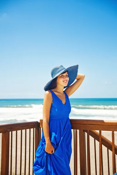 Vrouw in blauwe jurk op de Oceaan kust van bali — Stockfoto