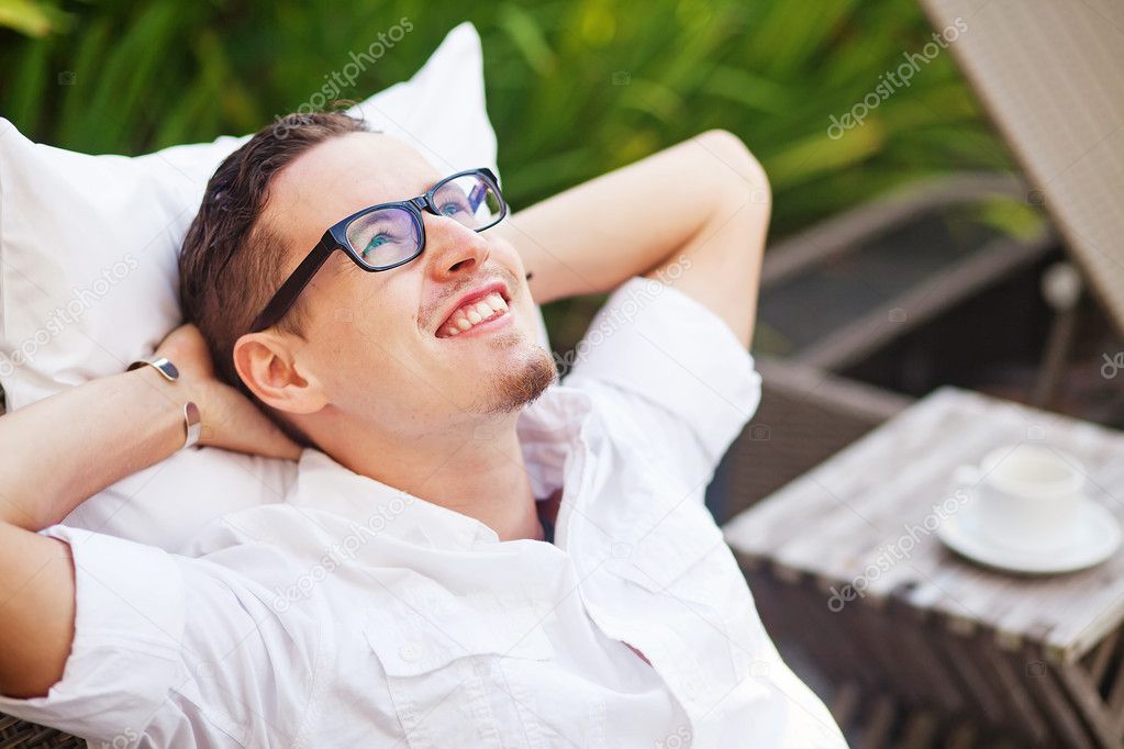 Handsome man on the outdoor bed in the garden of house