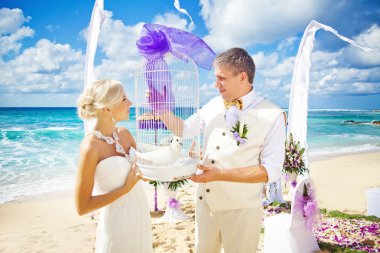 Wedding in bali - couple holding doves clipart