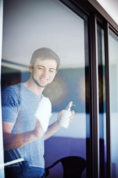 Мужчина моет окно дома — стоковое фото