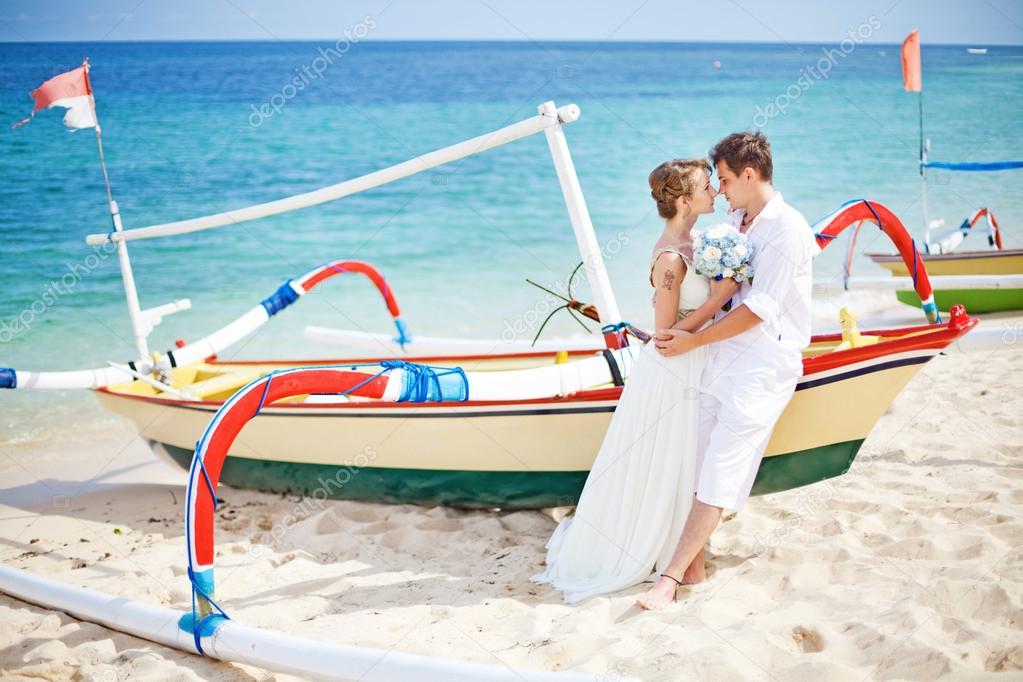 Couple on a beach near the boat