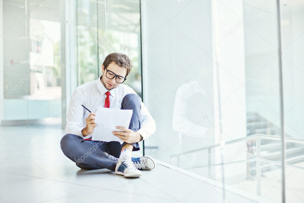 Businessman or student sitting on a floor