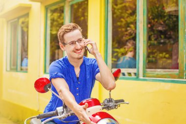 onun motosiklet üzerinde telefonda konuşan adam
