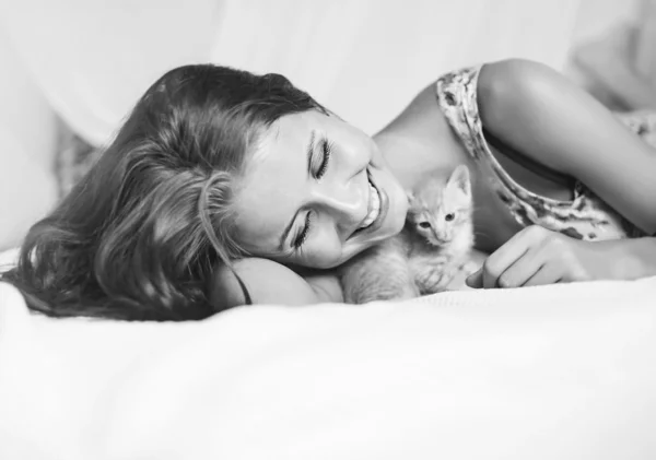 Mujer relajándose en la cama con gatito —  Fotos de Stock