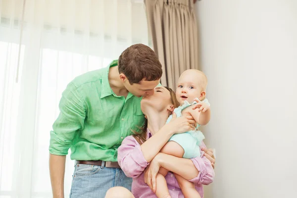 Couple kissing white holding baby — Stock Photo, Image