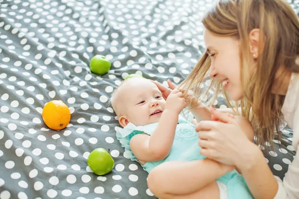 Baby snatching strand of mother's hair — Stock Photo, Image