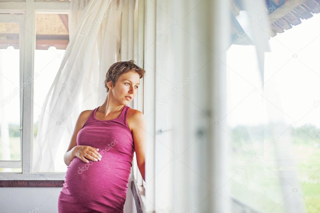 Pregnant woman near the window