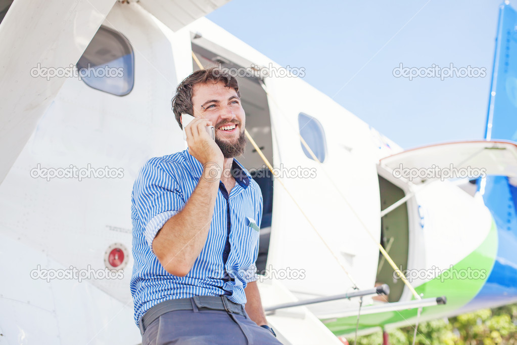 Man calling on phone near airplane