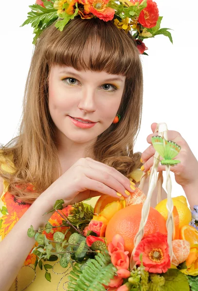 Mädchen hält Korb mit Früchten und Blumen — Stockfoto