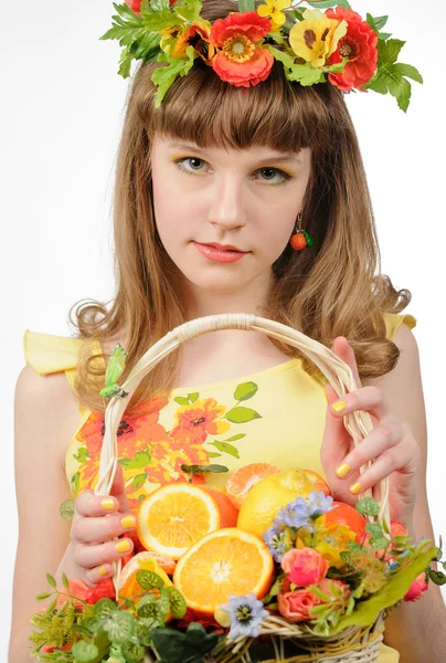 Mädchen hält Korb mit Früchten und Blumen — Stockfoto