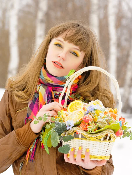 Girl holding basket with fruits and flowers — Stock Photo, Image