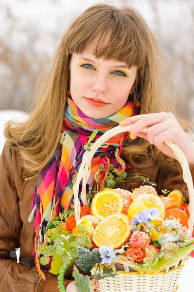 Girl holding basket with fruits and flowers — Stock Photo, Image
