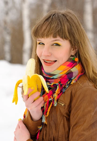 Smiling girl biting a banana — Stock Photo, Image