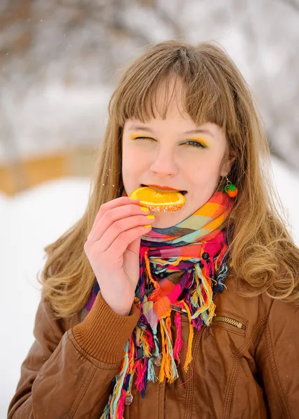 Mädchen beißt in Orangenscheibe — Stockfoto