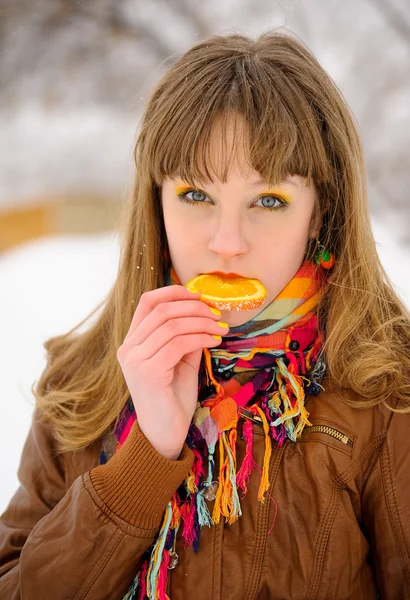 Girl biting orange slice — Stock Photo, Image