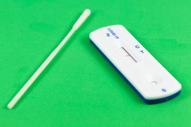 Test değişimiyle SARS-CoV-2 hızlı antikor testi ve yeşil arkaplan üzerinde negatif test sonucu