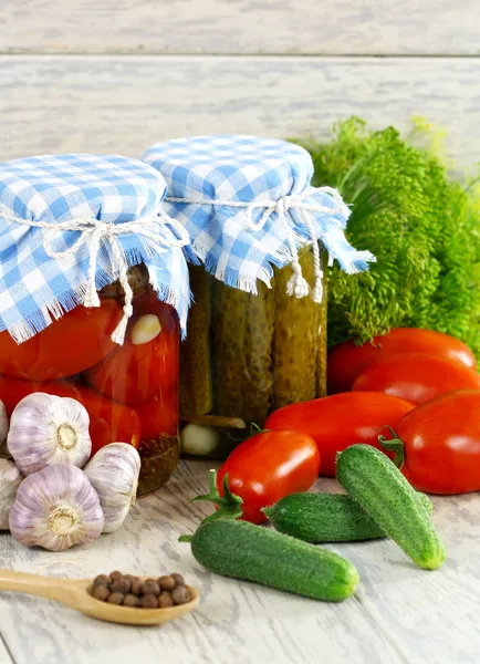 Konserverade och färska tomater och gurkor, kryddor på en trä flik — Stockfoto