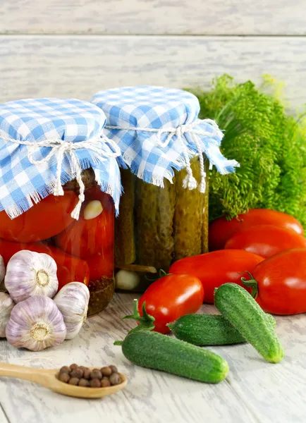 Tomates y pepinos enlatados y frescos, especias en una lengüeta de madera —  Fotos de Stock