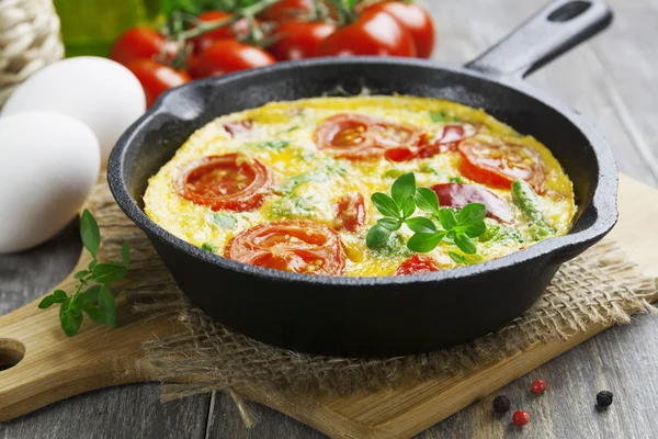 Omelet med grøntsager og ost. Frittata - Stock-foto