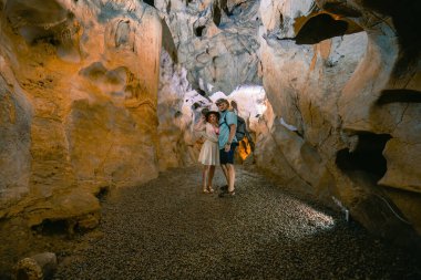 Arkadan bak. Mağarayı keşfeden iki turist. Mağaranın içi. Turistik yürüyüş rotası. Gezinti ve eğlence anlayışı. (Cuceler magarasi) Tirilar, Sapadere, Alanya