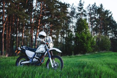 Enduro off road Motorsikleti Yeşil Çim Tepesi manzarası Çam Ormanı Günbatımı