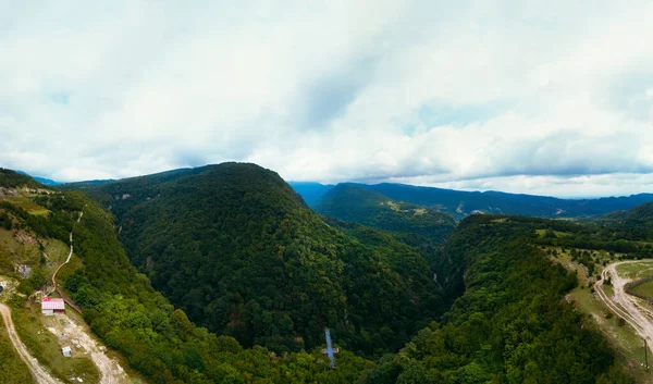 奥卡斯特峡谷开阔的空中视野 高山上覆盖着绿色的森林 自然景观 假期和旅行 格鲁吉亚的旅游胜地 金属桥 以探测该区域 — 图库照片