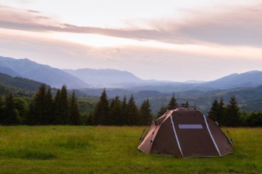 Kahverengi çadır. Hızlı kurulum sistemi. Yaz günü. Dağlar ve orman, seyahat ve turizm konsepti. Kamp yapmak. Boşluğu kopyala.