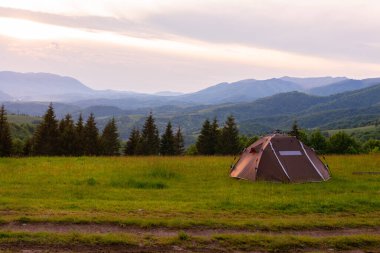 Kahverengi çadır. Hızlı kurulum sistemi. Yaz günü. Dağlar ve orman, seyahat ve turizm konsepti. Kamp yapmak. Boşluğu kopyala.