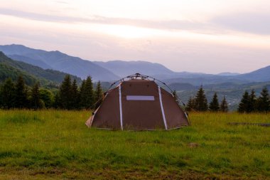 Kahverengi çadır. Hızlı kurulum sistemi. Yaz günü. Dağlar ve orman, seyahat ve turizm konsepti. Kamp..