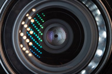 Professional camera photo lens. Details of glass, layer of enlightenment, aperture petals. Light reflections from modern diode lamps. The concept of making visual content.