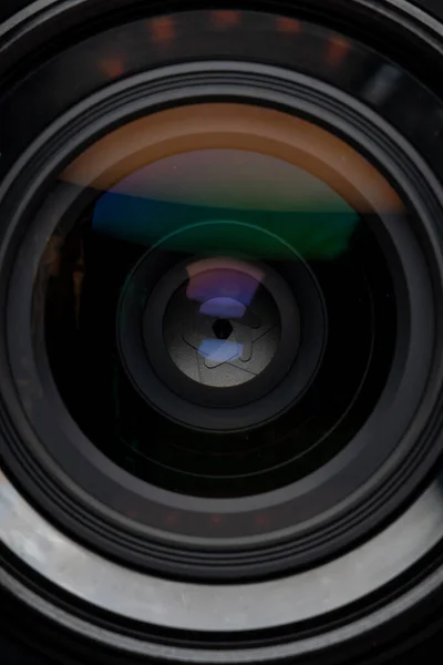 Profesyonel fotoğraf makinesi lensi. Cam parçaları, aydınlanma katmanı, açıklık yaprakları. Modern diyot lambalarının ışık yansımaları. Görsel içerik oluşturma kavramı. Dikey fotoğraf.