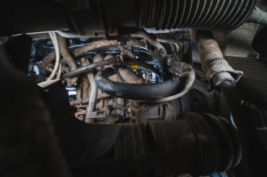 Oil, coolant and freon from the air conditioner, connections and clamps. troubleshooting. Car service. rubber pipe fluid leak from vehicle. View from the pit, under car, detection. Selective focus