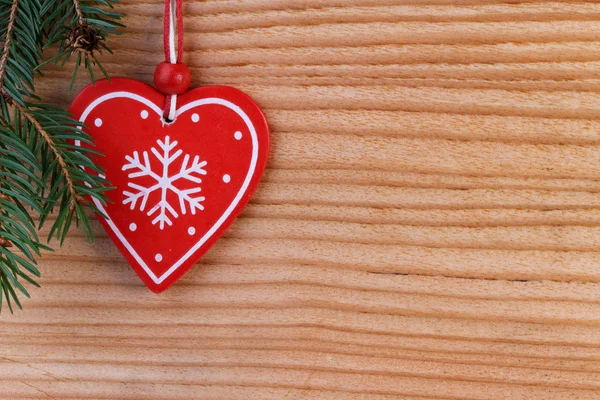 Corazón rojo sobre fondo de madera, decoración navideña — Foto de Stock