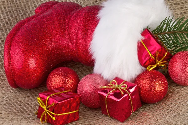 Santa claus boot z prezentów na tle juty — Zdjęcie stockowe