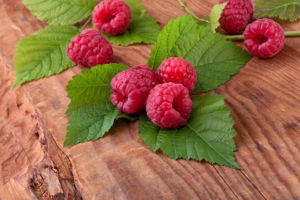Raspberry with leaves on wood background — Stock Photo, Image