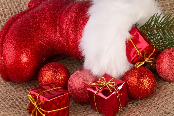 Bottes de Père Noël avec des cadeaux sur fond de jute — Photo