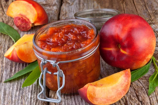 Nectarine, peach jam on wood background — Stock Photo, Image