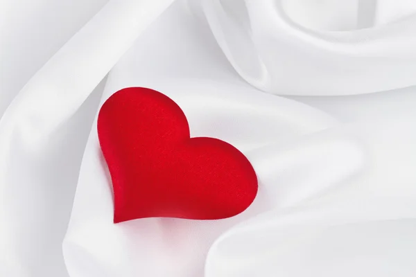 Rood hart op witte zijde — Stockfoto