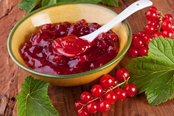 Rote Johannisbeermarmelade mit frischen Beeren Stockfoto