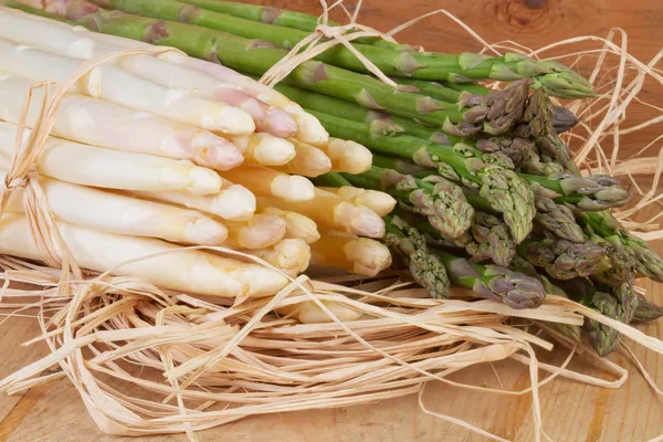 Fascio di asparagi verdi e bianchi su tavola di legno — Foto Stock