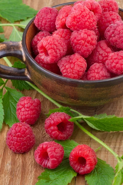 Fresh raspberry in a cup on wooden table — Stock Photo, Image