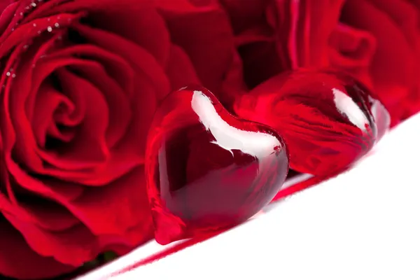 Corazón rojo con flores de rosa, se centran en el primer plano — Foto de Stock