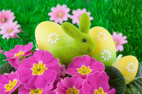 Пасхальный кролик с пасхальными яйцами на зеленой траве — стоковое фото