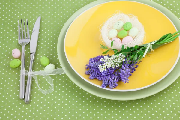 Easter Table Setting with Spring Flowers and Eggs on Green Polka Dot Tablecloth — Stock Photo, Image