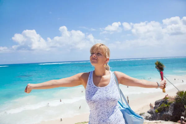 Giovane donna che allunga le braccia sulla spiaggia — Foto Stock