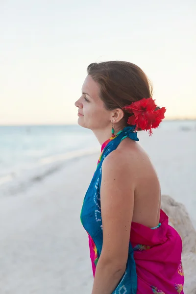 Ung kvinna sitter på stranden — Stockfoto
