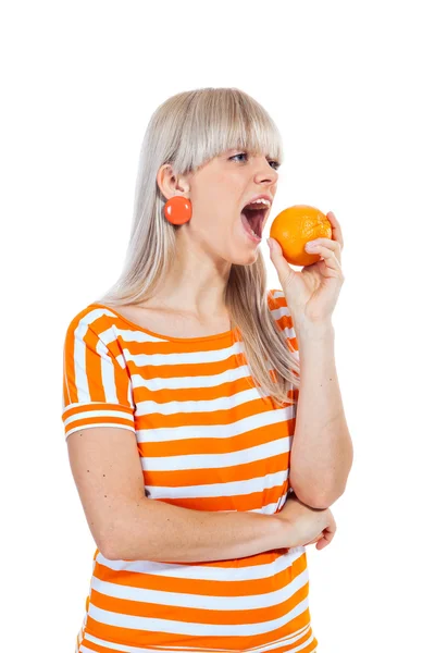 Schönes Mädchen beißt orange — Stockfoto